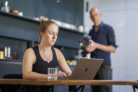 Symbolic photo on the subject of division of labour for couples in the household. A woman sits at a