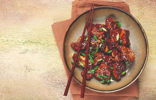Yakitori chicken kebab, on a plate, with green onions and sesame seeds, top view, no people