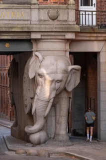 Pedestrian walking past monumental stone elephant, Elephant Gate or Elephant Portal or