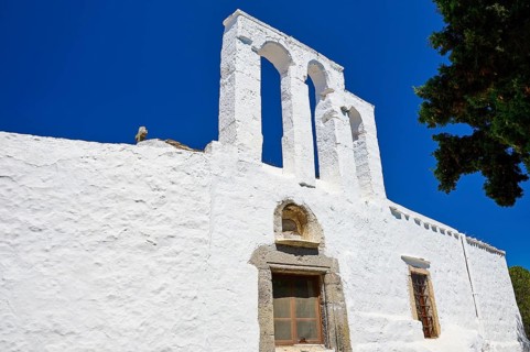 White church with a three-arched bell tower against a clear blue sky, Greek architecture, Chora,