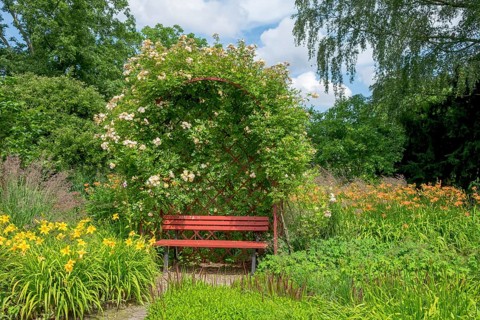 Red bench in the district educational garden, Burgsteinfurt, Münsterland, North Rhine-Westphalia,