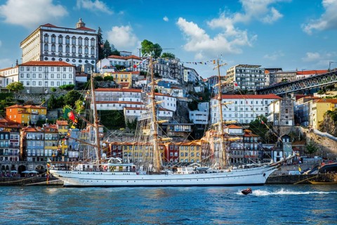 View of Porto city and Douro river with sailing ship from famous tourist viewpoint Marginal de Gaia