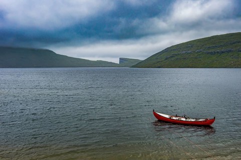 Little red boat in a lake in Vagar, Faroe islands, Denmark, Europe