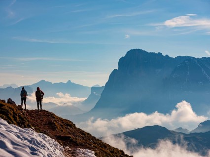 Two mountaineers with a view of Sassolungo, clouds in the valley, Sciliar, Dolomites, South Tyrol,