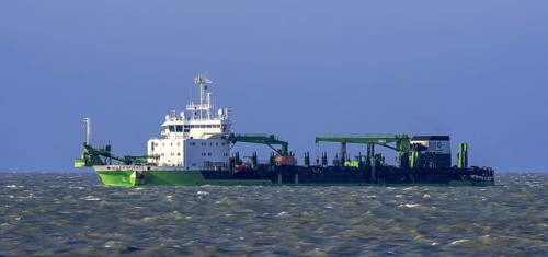 DEME trailing suction hopper dredger Uilenspiegel at sea, used for sand replenishment, beach