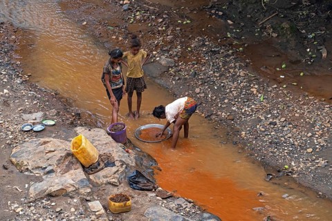 Young girls panning for gold in stream at Dabolava, gold miners' village near Miandrivazo, Menabe