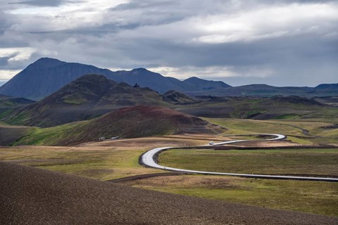 Road through volcanic landscape with colourful hills, Krafla geothermal area, Northern Iceland,