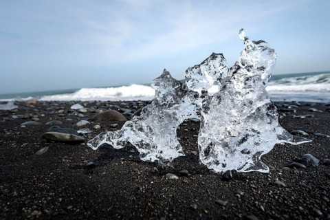 Ice, piece of ice on black sand beach, on black lava beach Diamond Beach, Southeast Iceland,