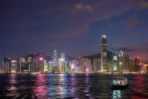 Hong Kong skyline cityscape downtown skyscrapers over Victoria Harbour in the evening illuminated