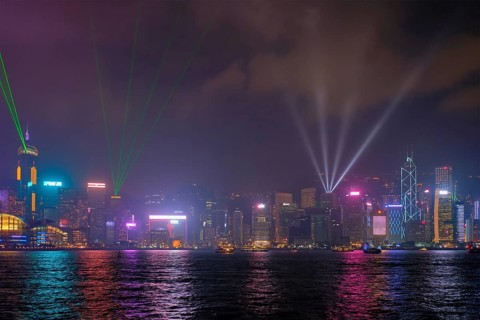 Hong Kong skyline cityscape downtown skyscrapers over Victoria Harbour in the evening illuminated