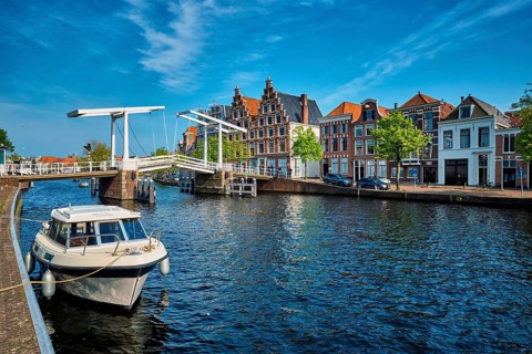Spaarne river with boat and Gravestenenbrug bridge famous tourist landmark in Haarlem, Netherlands