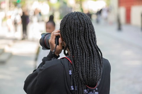 Young girl with black dreadlocks taking a photo, Paris, France, Europe