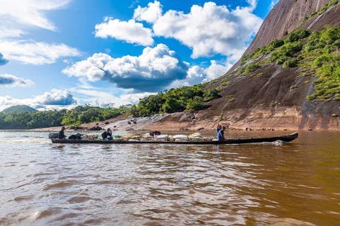 Fisherman with their fish before the huge granite hills, Cerros de Mavecure, Eastern Colombia