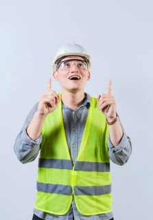 Surprised young architect pointing up. Amazed engineer pointing at an advertisement. Engineer with