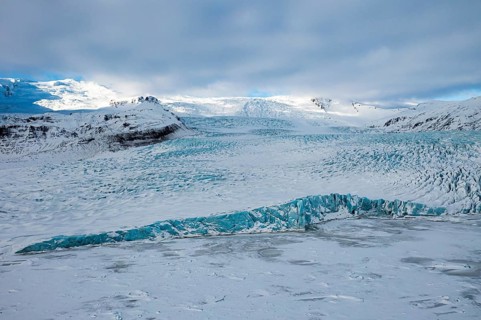 Snow-covered icebergs in the Fjallsarlon glacier lagoon, with the Öraefajökull glacier behind,