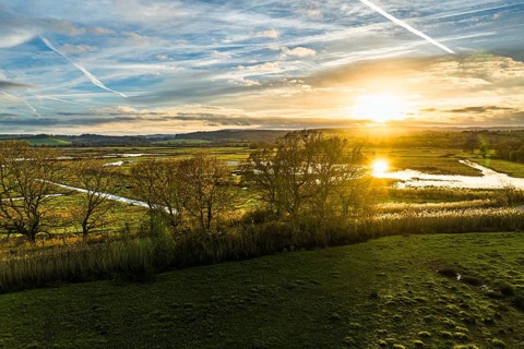 Sunset over Wetlands and Marshes in RSPB Exminster and Powderham Marshe from a drone, Exeter,