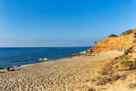 Tourists on the sandy beach, red rocks, holiday by the sea, Spiaggia di Scivu, Arbus, Costa Verde,