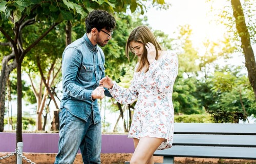 Young couple arguing misunderstanding in a park, Unhappy couple standing arguing in a park.