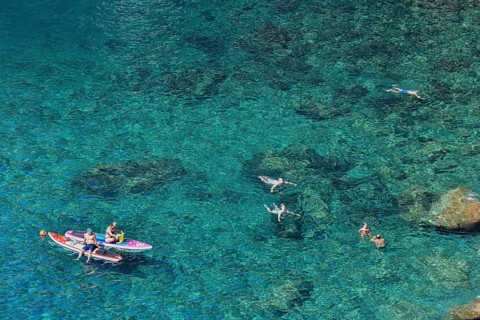 Bathers in the rocky bay of Corniglia, Cinque Terre, province of La Spezia, Liguria, Italy, Europe