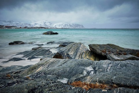 Waves of Norwegian sea on rocky beach of fjord. Ramberg beach, Lofoten islands, Norway, Europe