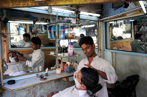 08.12.2011, Mumbai, Maharashtra, India, Asia, A barber shaves a customer in a small men's parlour