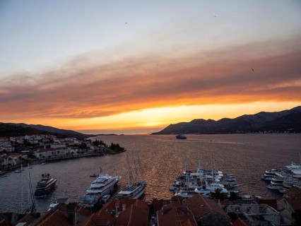 Evening atmosphere at sunset by the sea, view from the bell tower, ships in Korcula harbour,