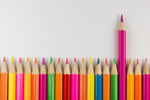 Abstract composition of a set wooden colour pencils against a white background
