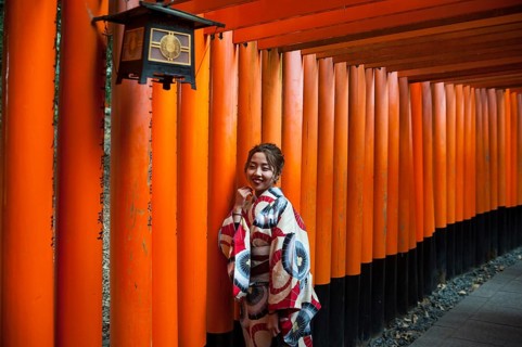 24.12.2017, Kyoto, Japan, Asia, A young Japanese woman stands in one of the torii pathways leading