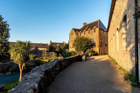 Picturesque narrow street of the medieval village of Locronan a sunny day of summer at evening