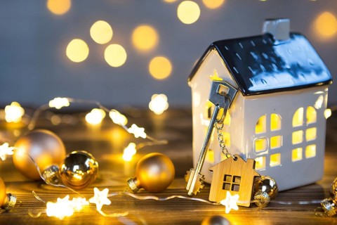 Key to the house with a keychain on a lamp with a Christmas decor. A gift for New Year, Christmas.