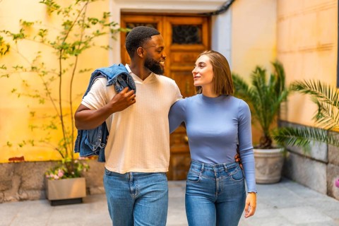 Beauty mixed-race couple with denim casual clothes walking together leaving the house