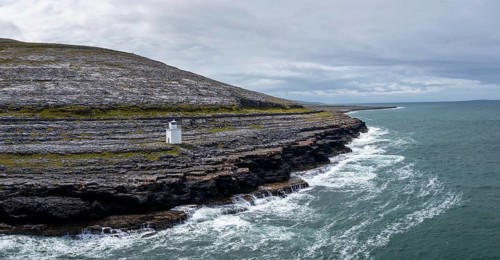 An aerial view of the Burren Coast in County Clare with the Black Head Lighthouse on the rocky