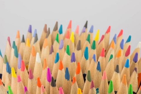 Abstract composition of a set wooden colour pencils against a white background