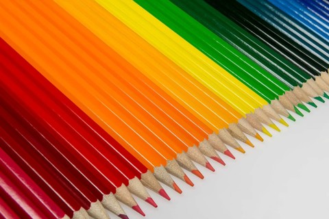Abstract composition of a set wooden colour pencils against a white background