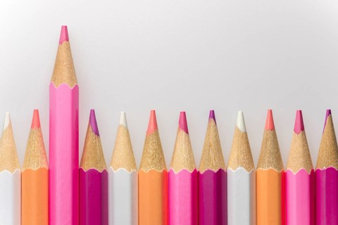 Abstract composition of a set wooden colour pencils against a white background