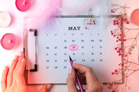Calendar 9th of May date. Candles flowers feather. Happy Mothers day. Planning holiday. Flat lay.