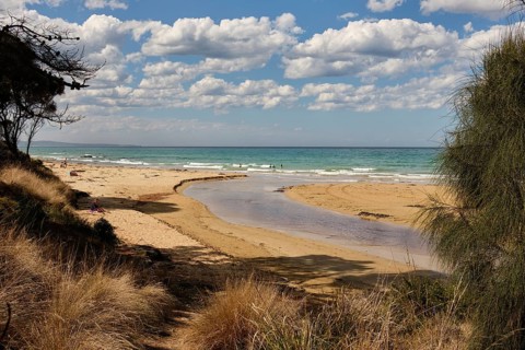 Beachgoers enjoy the surf, the refreshing water, the sun and the sand at the mouth of the Erskine