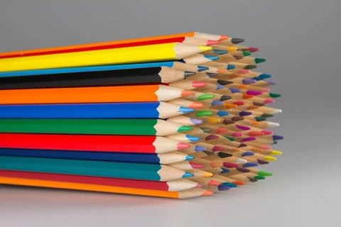 Abstract composition of a set wooden colour pencils against a white background