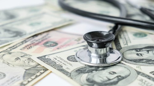 Stack of cash dollars and stethoscope. The concept of medical expensive medicine, doctors salary.