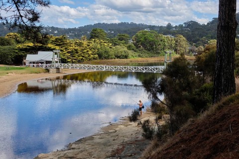 An angler at a lovely spot by the Erskine River near the Swing Bridge, Lorne, Victoria, Australia,