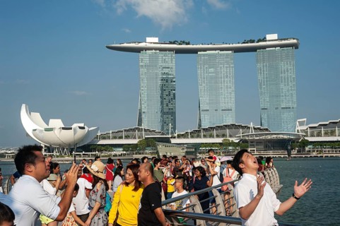 01.08.2019, Singapore, Republic of Singapore, Asia, Tourists pose for photos in Merlion Park on the