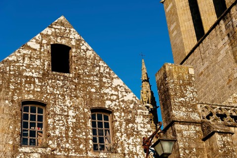 Close up detail of the facade of the churh of Saint Ronan in Locronan against blue sky