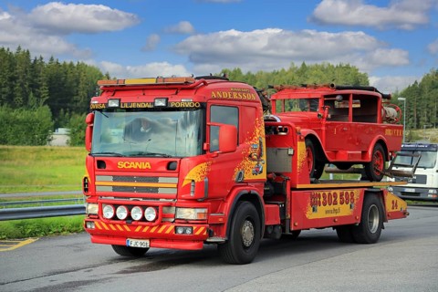 Scania flatbed tow truck of Hinaus Andersson Oy carrying a vintage fire truck. Salo, Finland.