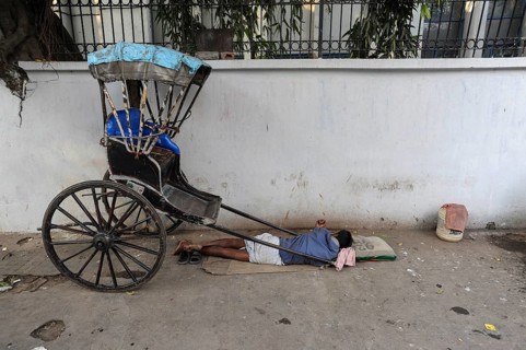 25.02.2011, Kolkata, West Bengal, India, Asia, A rickshaw driver sleeps next to his wooden rickshaw