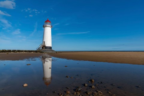 A view of the Point of Ayr Lighthouse and Talacre Beach in northern Wales with reflections in a