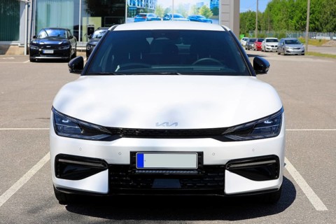 White Kia EV6 fully electric crossover car parked at the new car dealership. Front view. Salo,