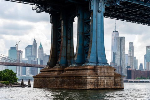 Detail of Pillar of Manhattan Bridge against cityscape of New York City. Steel Abutment With Bolt