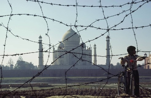 08.02.2004, Agra, Uttar Pradesh, India, Asia, A boy stands with his bicycle behind a barbed wire