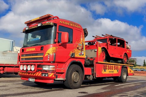 Scania flatbed tow truck of Hinaus Andersson Oy carrying a vintage fire truck. Salo, Finland.