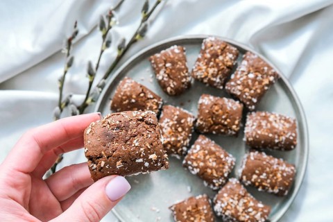 Female hand hold Oat cookies, oat dates energy, selective focus. Vegan sweets. Homemade bakery. Raw